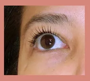 Close-up of an open eye with natural lashes lifted and curled after an LVL treatment