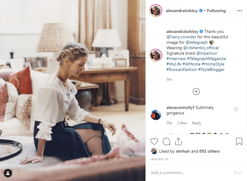 Instagram post of a signature braided hairstyle worn with a ruffled white blouse at home