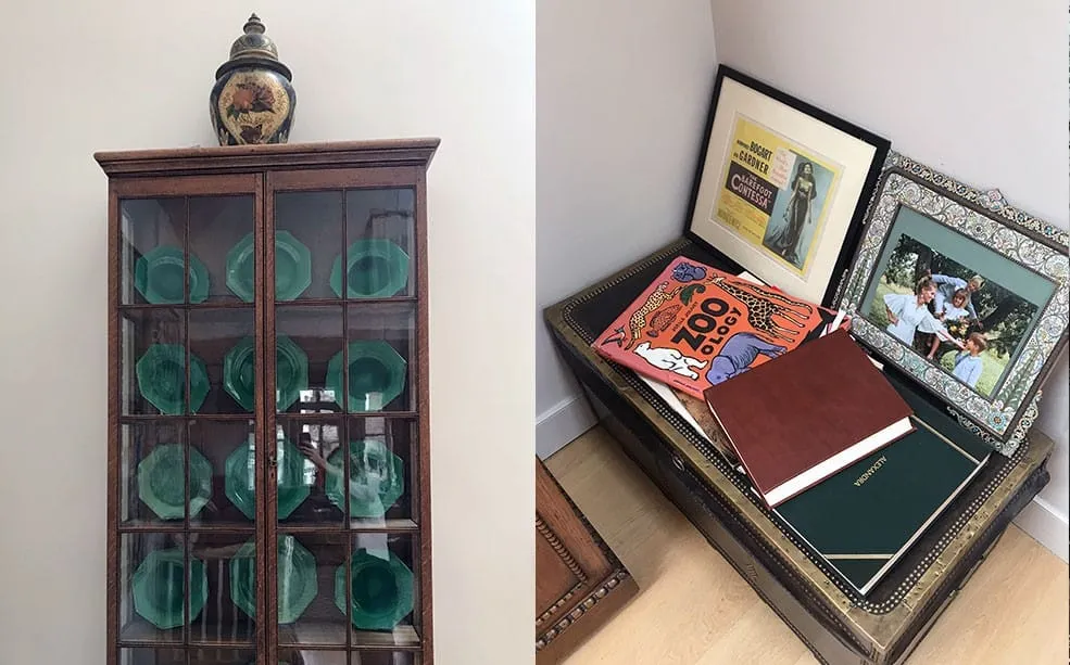 Display cabinet of green glass plates beside a trunk stacked with photo albums and framed pictures