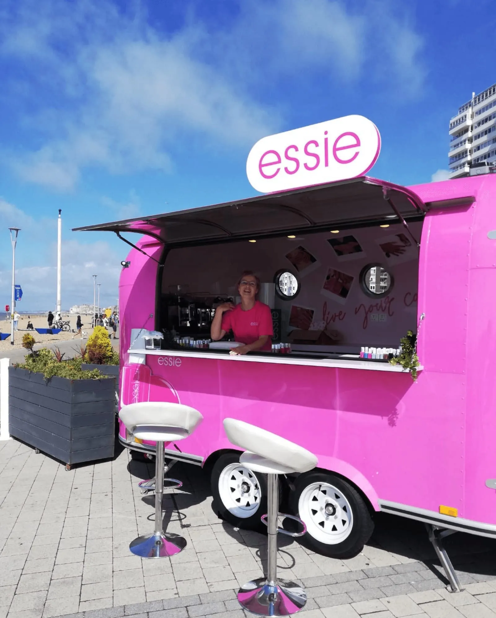 Bright pink essie manicure trailer on Brighton seafront with bar stools outside