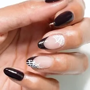 Black and nude Halloween nails with hand-painted white spider web tips