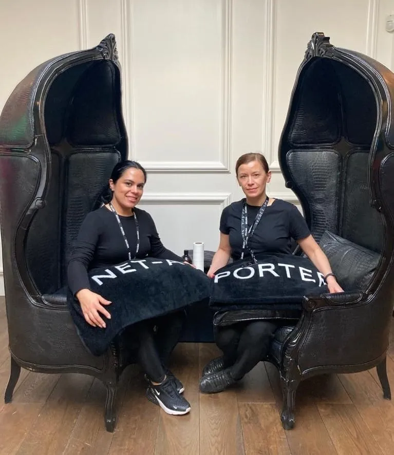 Two Secret Spa therapists in branded lanyards seated in Net-a-Porter canopy chairs before an office treatment day