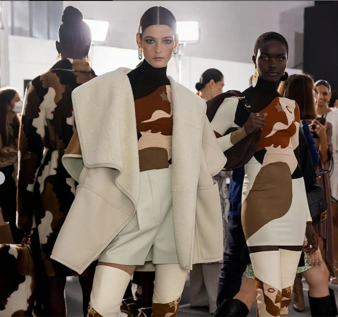Backstage catwalk models with sleek centre-parted hair slicked into low knots
