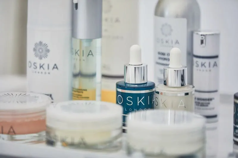 OSKIA London skincare range on a white tray, two serum dropper bottles in the foreground