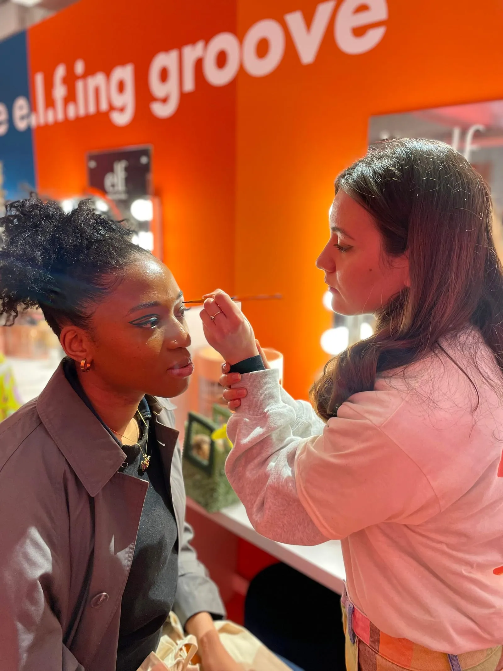 Make-up artist painting a graphic eyeliner look on a guest at the e.l.f. Cosmetics launch