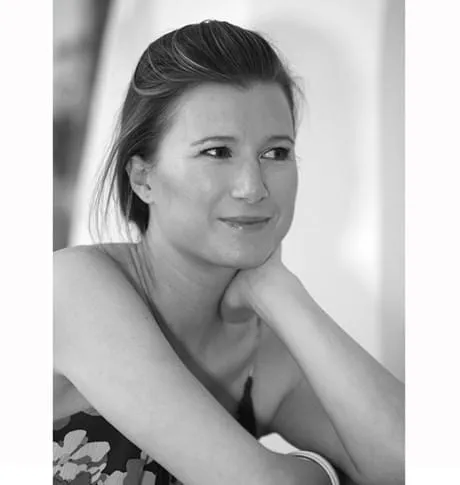 Black and white portrait of OSKIA founder Georgie Cleeves resting her chin on her hand