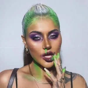 Zombie glam make-up with purple smoky eyes, dark lips and green paint through the hair and nails