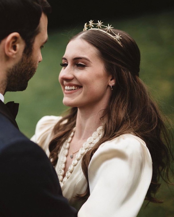 Smiling bride in a star tiara, hair worn half-up with a soft glowing bridal make-up look